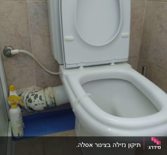 אסלה עם צינור מים וחיבורי אינסטלציה